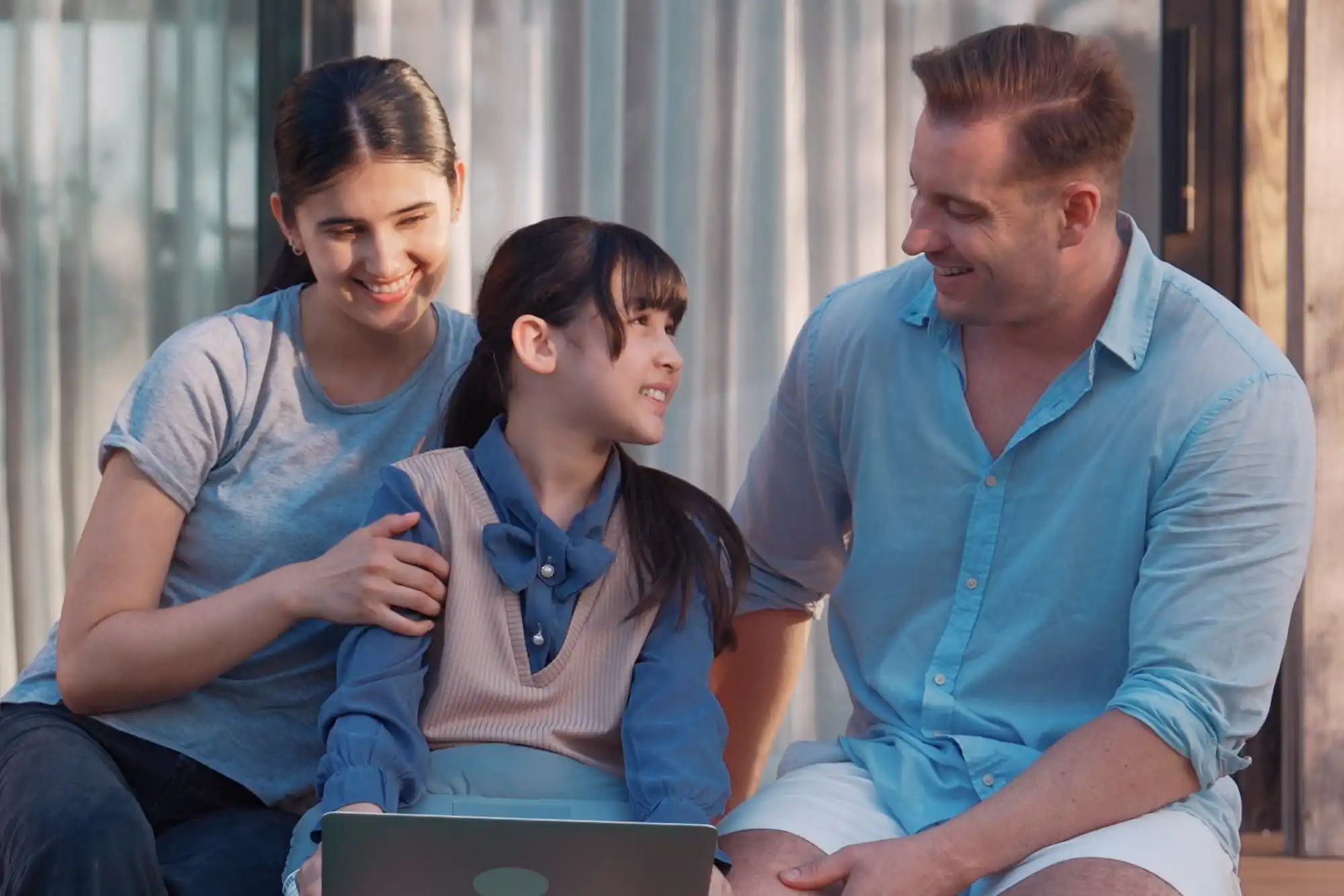 Smiling family sitting together, representing a healthcare approach that supports the whole family.