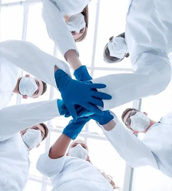 Team of doctors joining hands in solidarity, symbolizing unity and collective support against trauma.