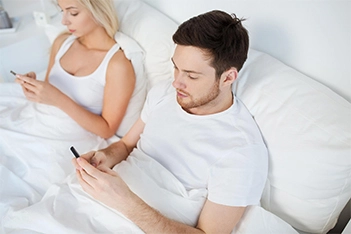 Unhappy couple sitting silently, emotionally affected by erectile dysfunction challenges.