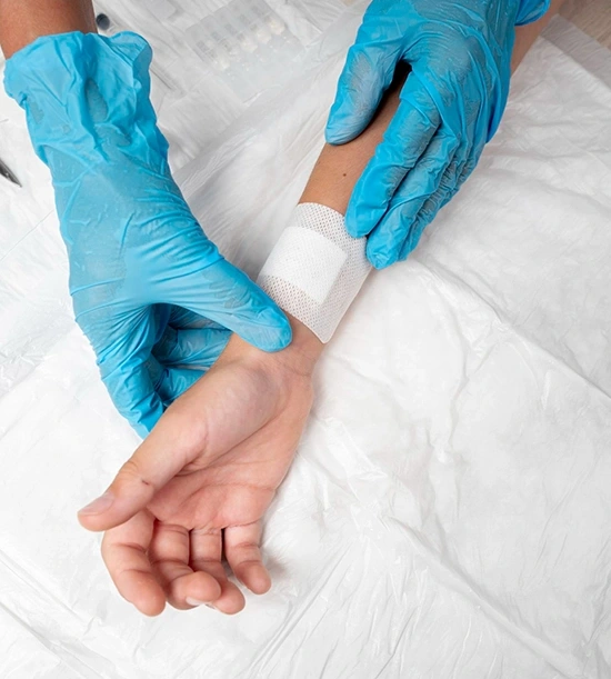 A doctor gently applying bandages to a patient's injured wrist during treatment.