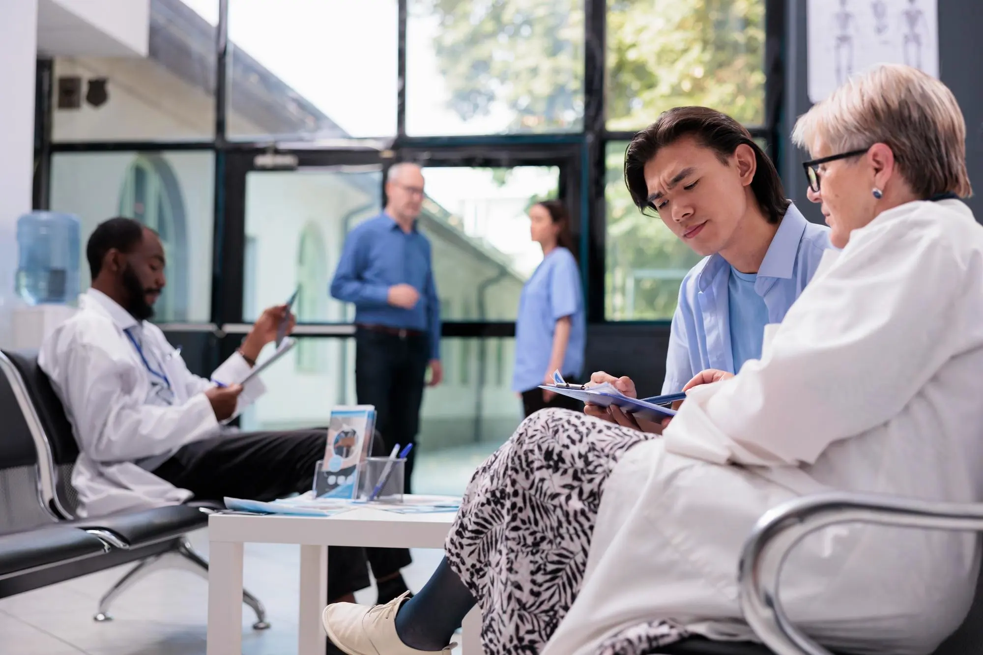 Doctor sitting beside an elderly woman, discussing her medical report with care.
