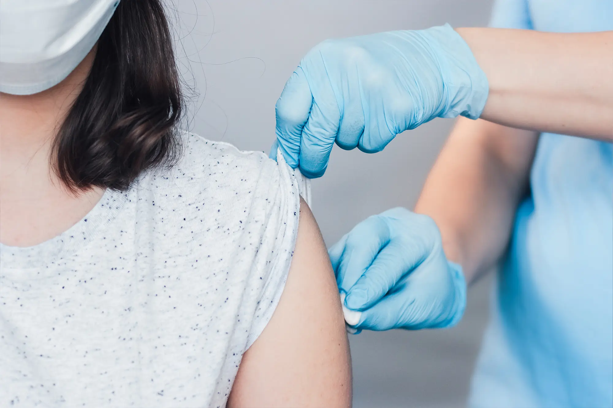Physician gently cleaning injection site after giving a high-dose flu shot to a patient.