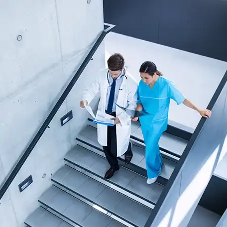 Female doctor reviewing X-ray scans with her colleague in a clinical setting.