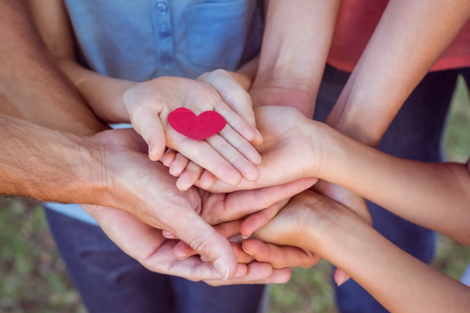 Community holding hands with heart icon to symbolize inclusive care and support for all individuals.