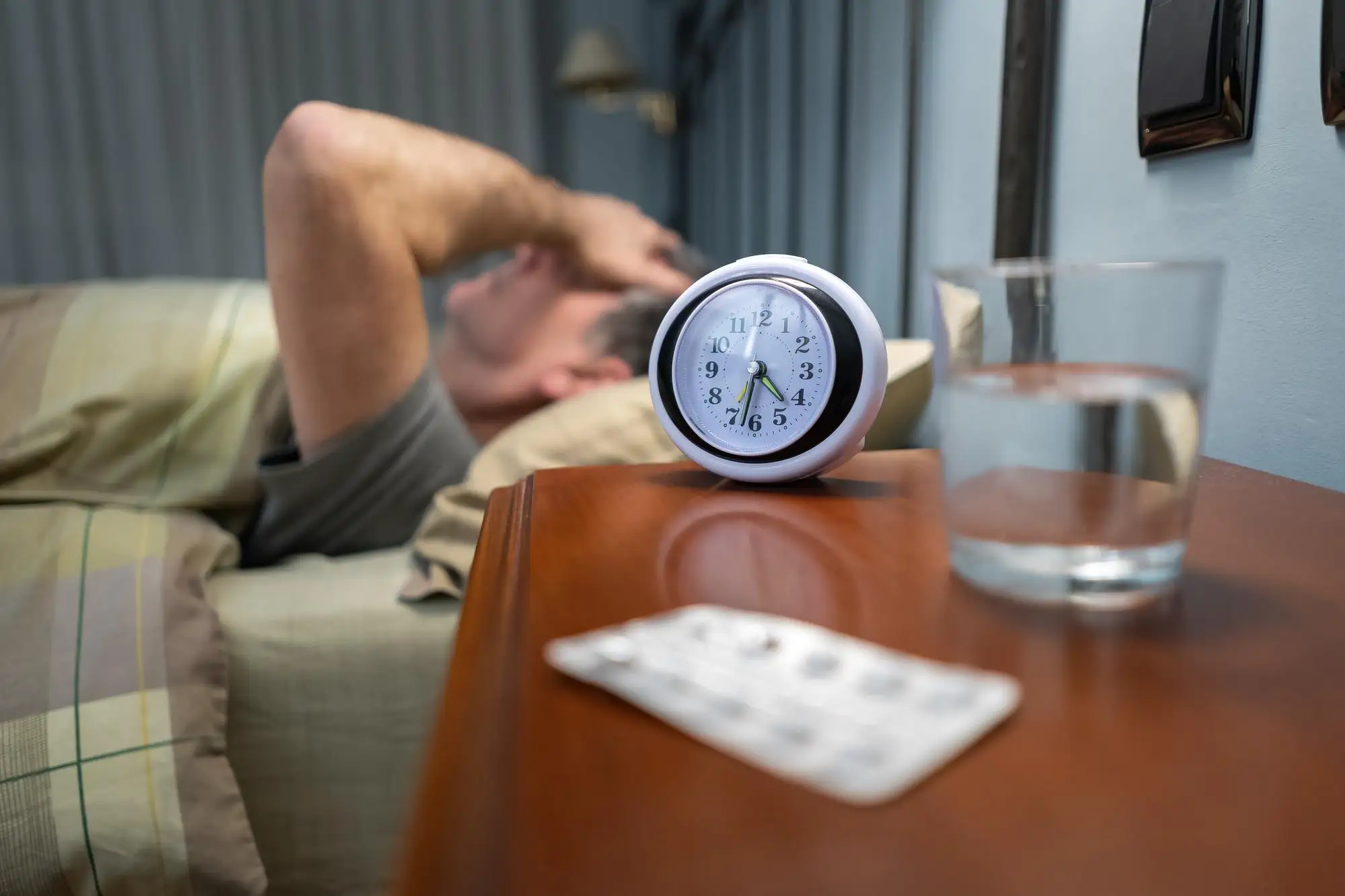 Man struggling to sleep at night due to ear pressure and discomfort caused by barotrauma.