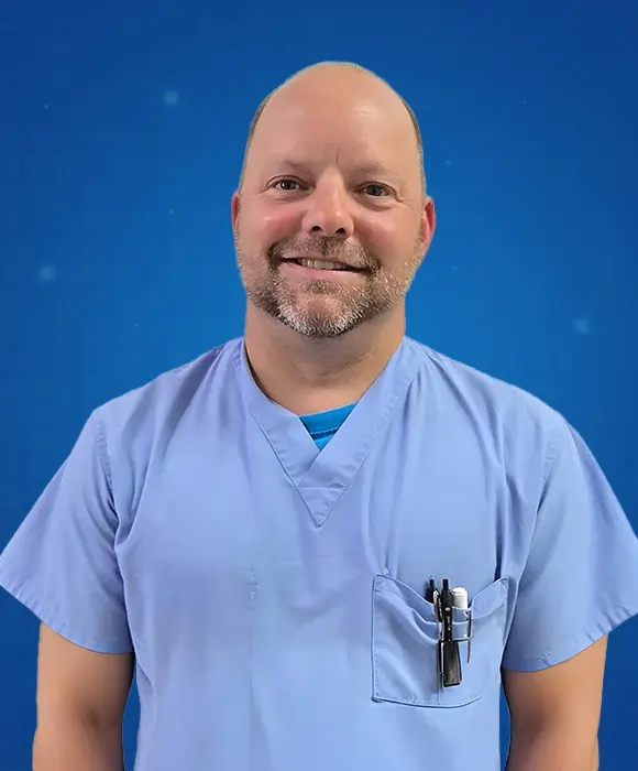 Micheal Barron Harrison, AGACNP-BC, healthcare provider at Rapid Care, standing in a professional medical setting.