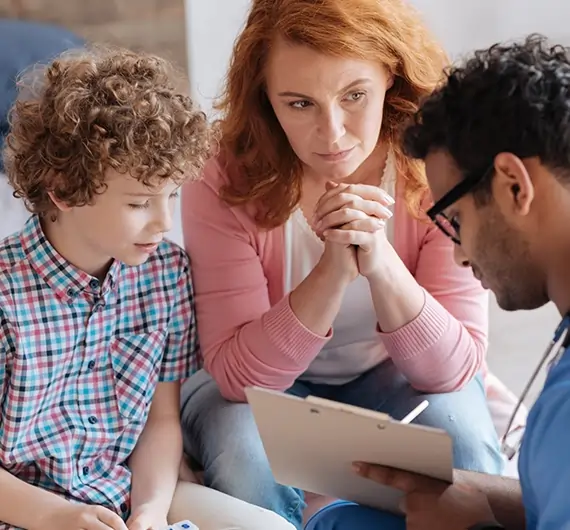 Parent consulting with pediatrician about child’s medical report during a check-up.