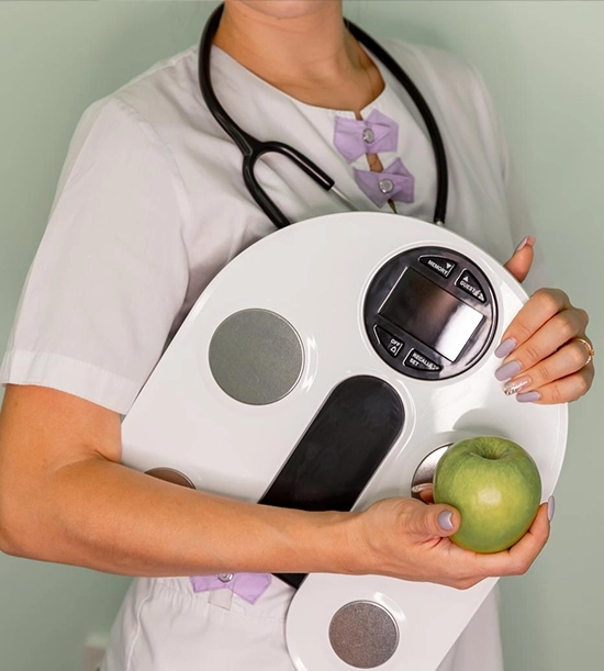 A nutritionist holding an apple and standing beside a weight scale, promoting healthy lifestyle and nutrition counseling.