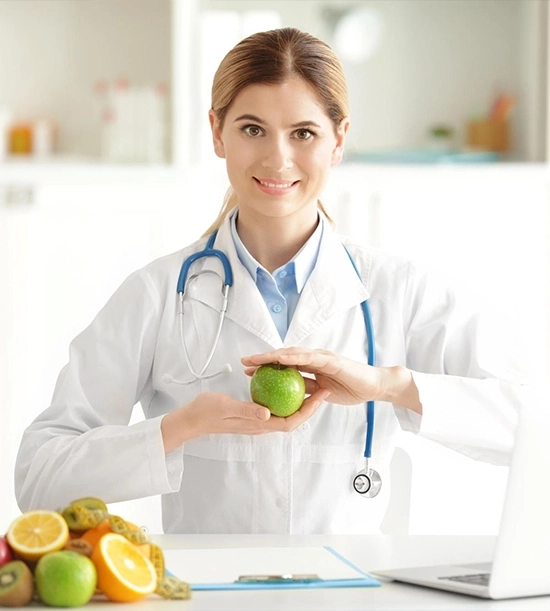 Nutritionist promoting weight loss strategy through healthy eating, holding an apple with various fruits on the table.