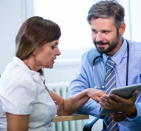 Doctor sharing medical report with senior woman after health checkup.