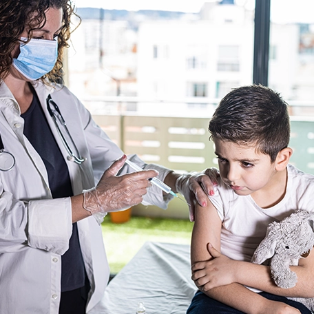 Teenage boy receiving a seasonal flu shot from a female provider during routine immunization.