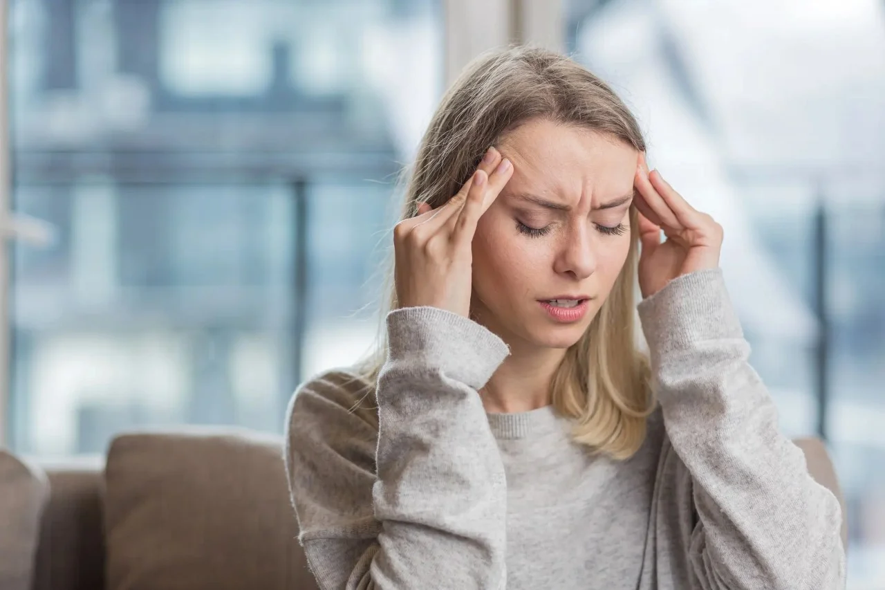 Woman experiencing tension headache due to high blood pressure.