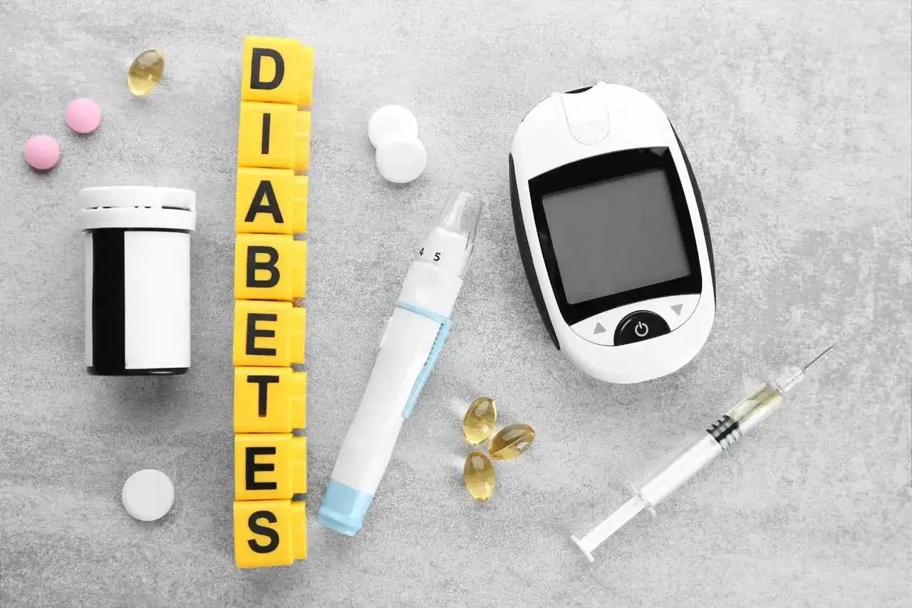 A flat lay image on a gray background featuring essential items for diabetes management