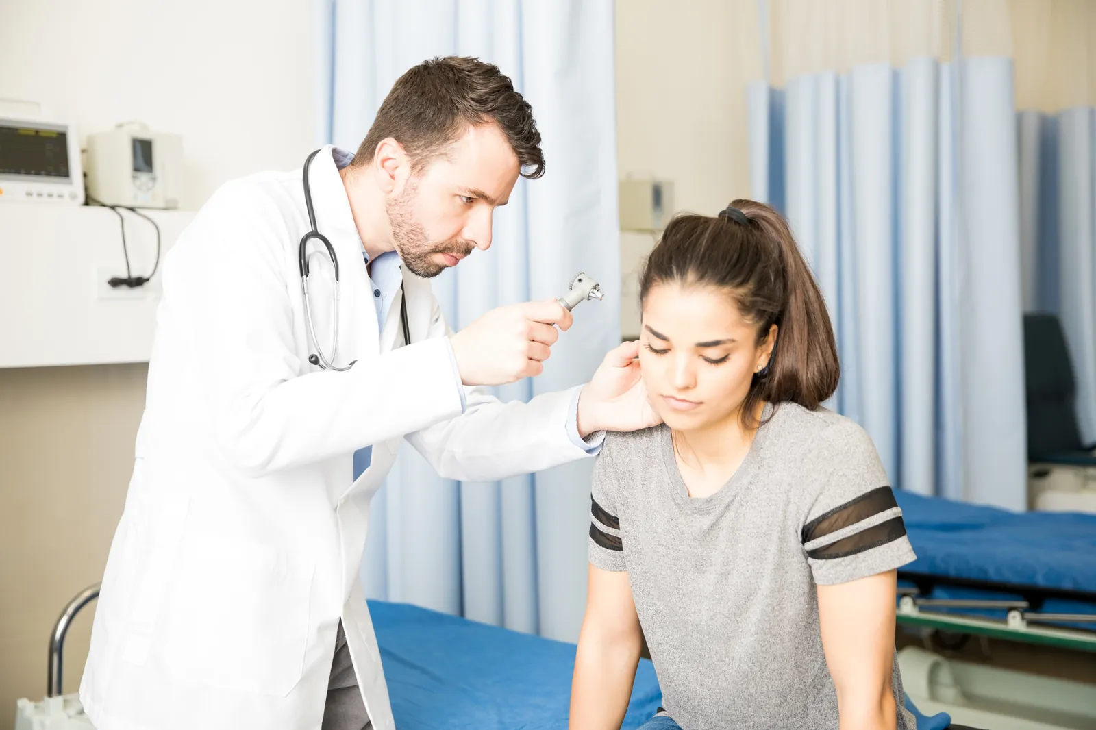 Doctor examining a patient's ear with an otoscope during a checkup in Fayetteville, NC