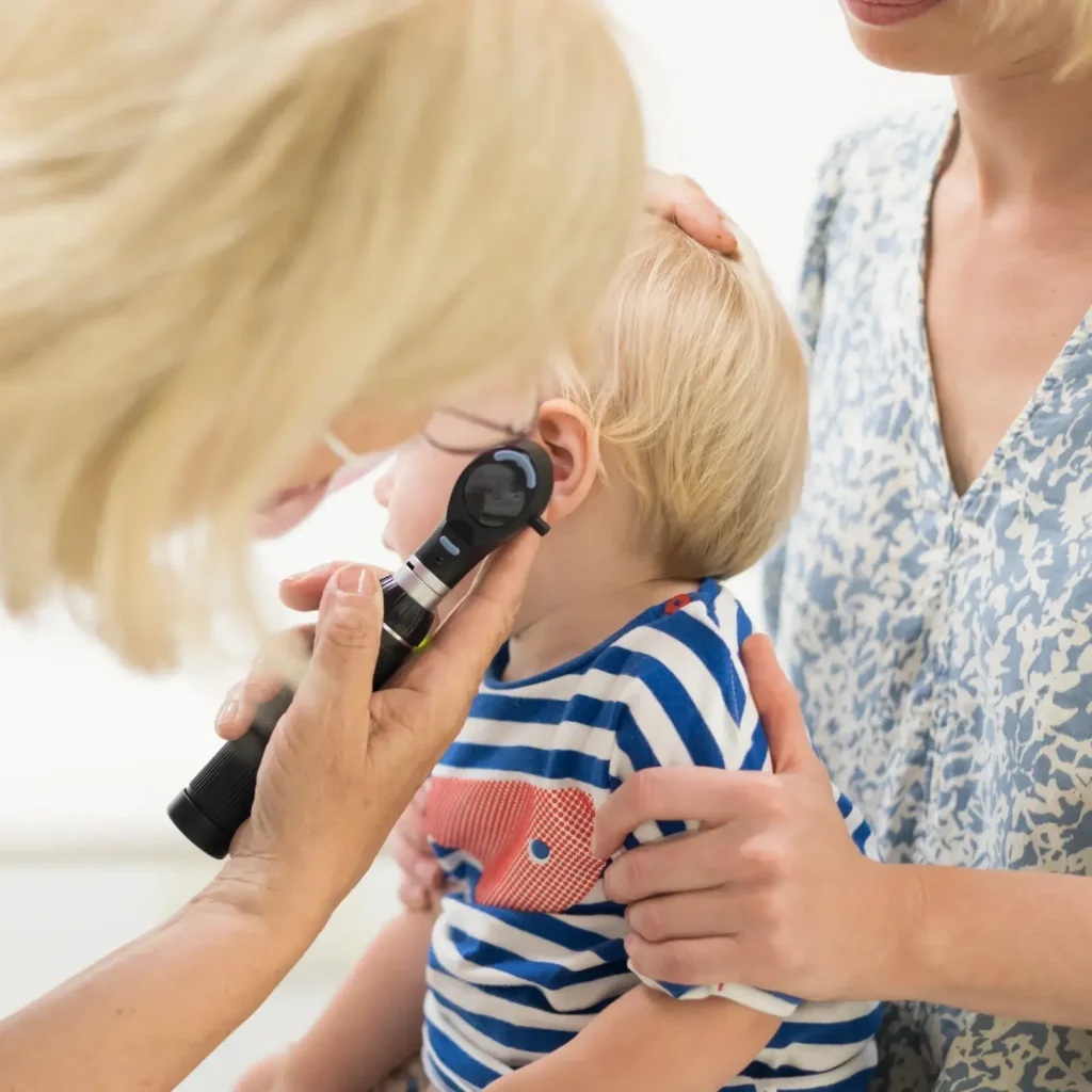 Pediatrician examining an infant's ear during a routine checkup