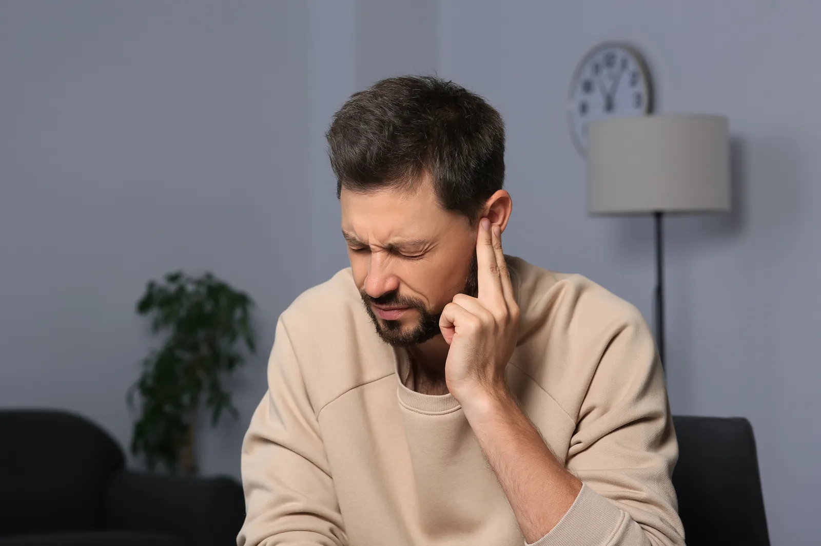 Man experiencing sharp ear pain at home in Fayetteville, NC