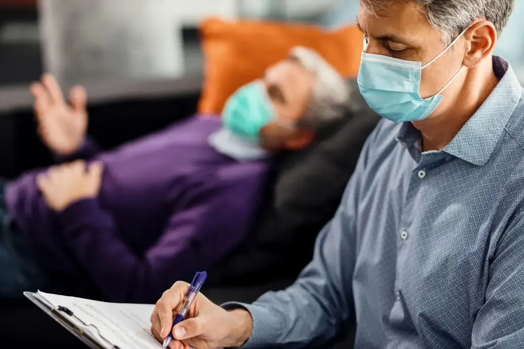Doctor checking on flu patient recovering at home