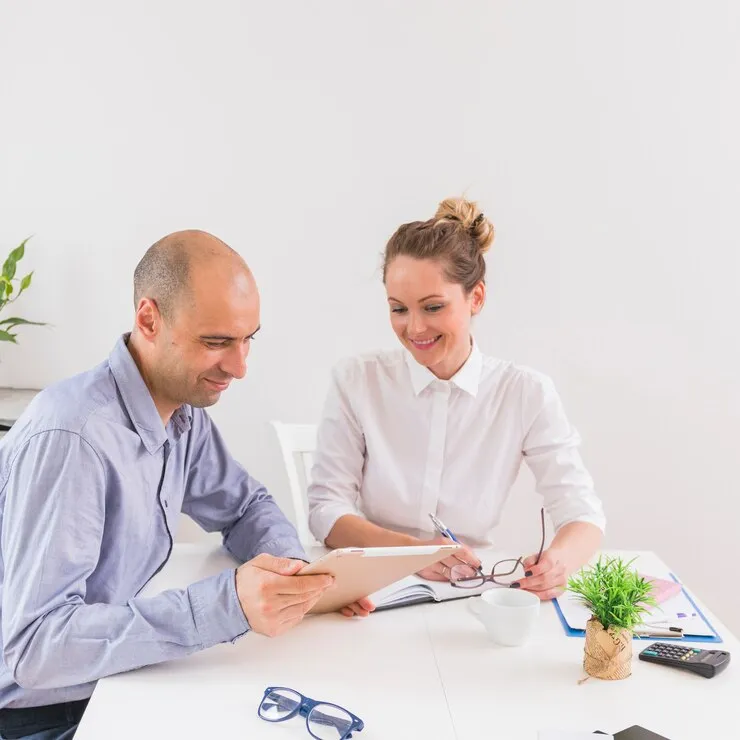 Female healthcare provider examining a male patient's hand during a medical consultation, with medication on the table