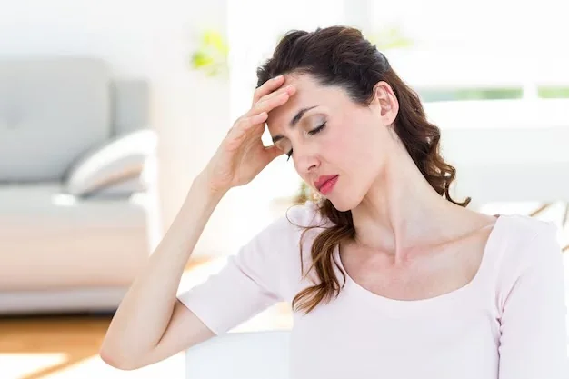 Woman with eyes closed and hand on her forehead, experiencing migraine pain