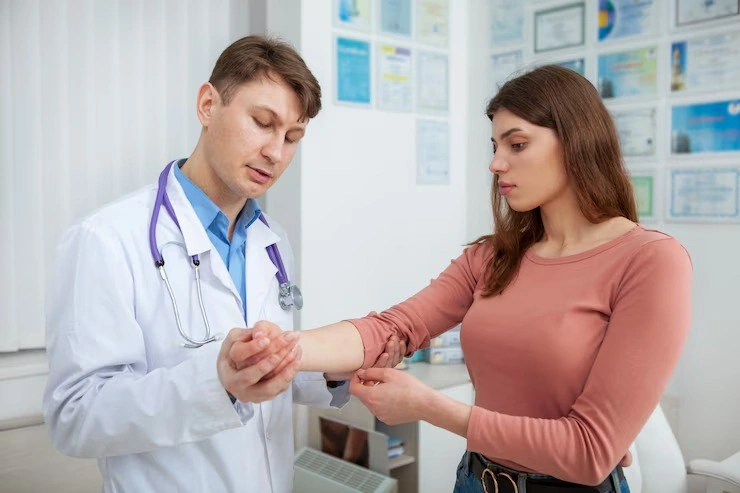 Doctor examining a young woman's injured wrist at Rapid Care, minor injury treatment in Fayetteville, NC