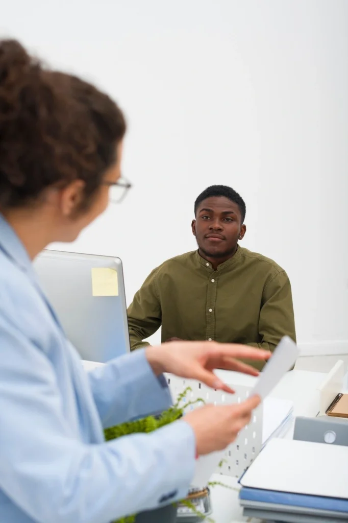 Clinic staff member explaining new patient paperwork to a patient at an STI clinic in Sanford, NC
