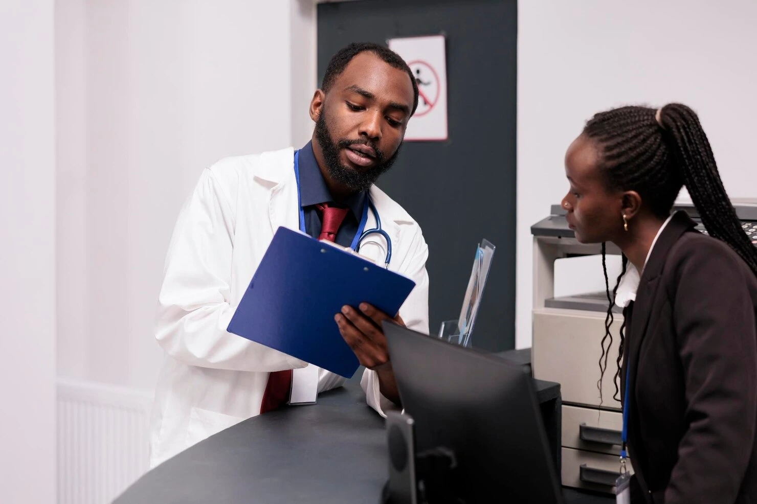 Doctor reviewing a patient chart with front desk staff at Rapid Care’s STI clinic in Sanford, NC